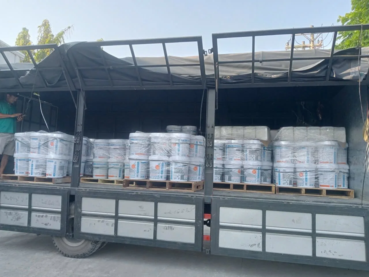 Xe tải chở đầy thùng sơn chống thấm MC BIFI, sẵn sàng phân phối.