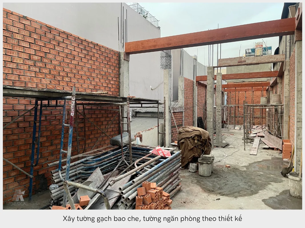Công trình đang xây dựng tường gạch bao che và tường ngăn phòng, với giàn giáo và vật liệu xây dựng.