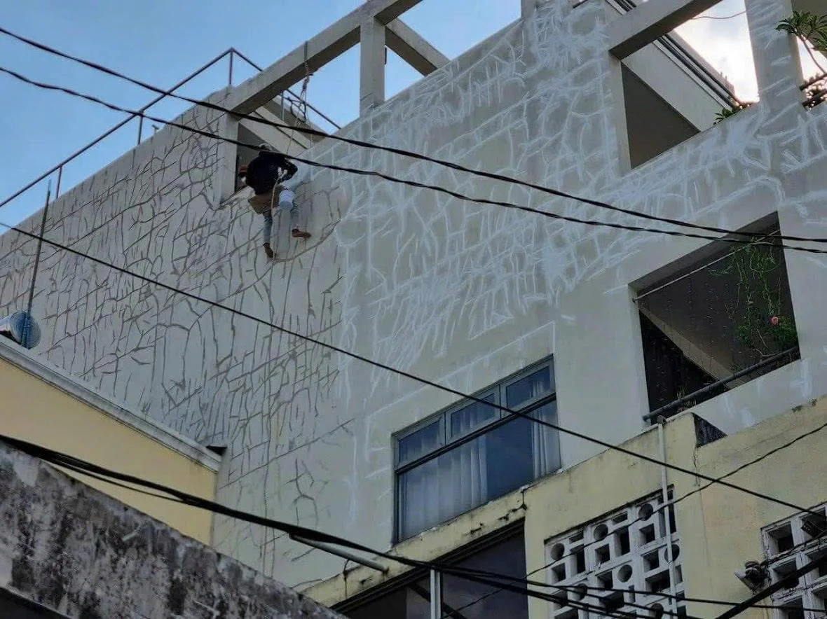 Thợ đu dây trám vết nứt tường ngoài tòa nhà